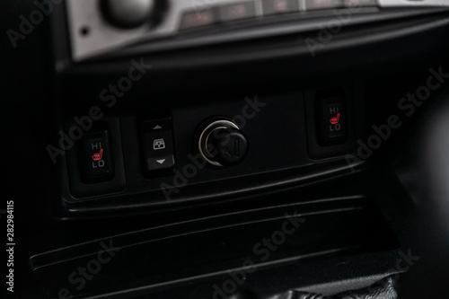 Close up of a charging in the car, cigarette lighter, seat heatting buttons. modern car interior..