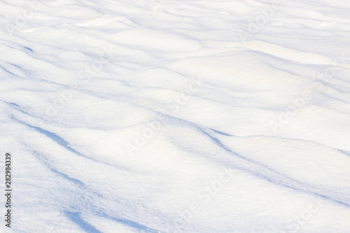 Natural winter background with snow drifts and falling snow.