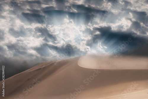 Beautiful gold sand dunes and dramatic sky with bright clouds in the Namib desert