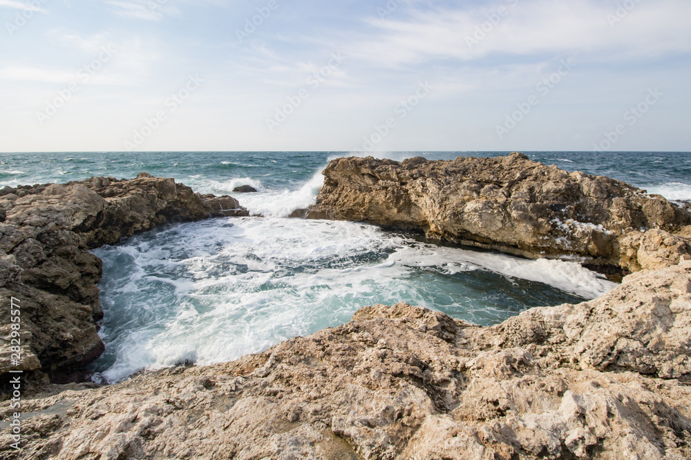 Sea waves crashing against the rocks. Day