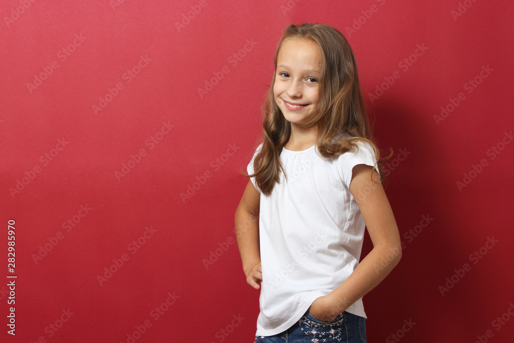Little cheerful smiling girl in fashionable clothes on a colored background. Children's clothing, children's fashion Little cheerful smiling girl in fashionable clothes on a colored background. Children's clothing, children's fashion