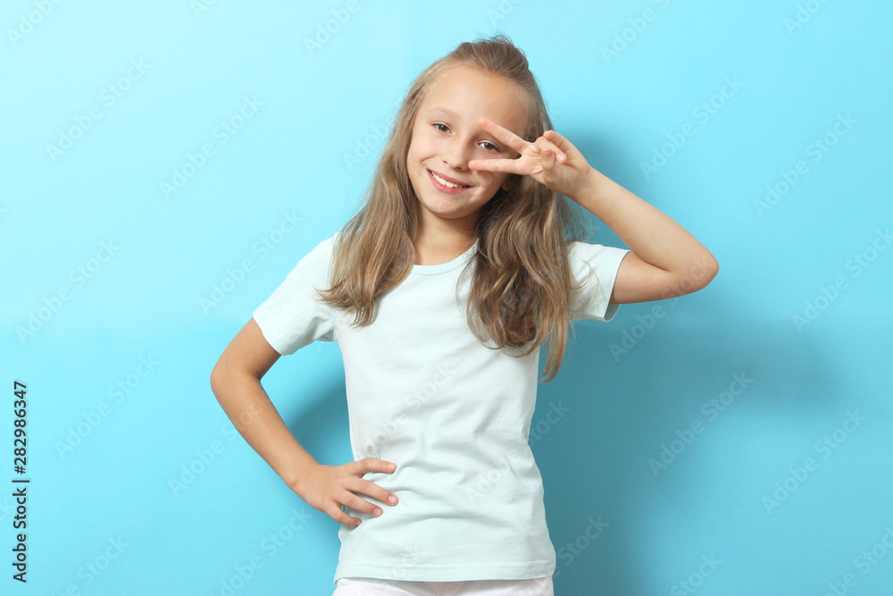 Little cheerful smiling girl in fashionable clothes on a colored background. Children's clothing, children's fashion Little cheerful smiling girl in fashionable clothes on a colored background. Children's clothing, children's fashion