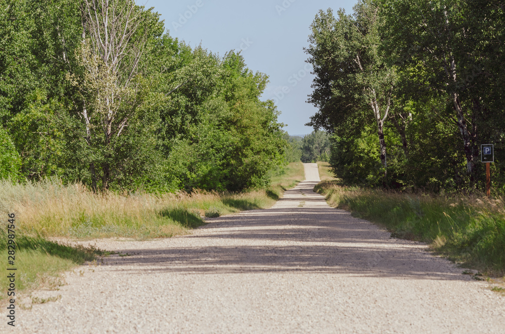 Gravel rural road at Riding Mountain National Park, Manitoba