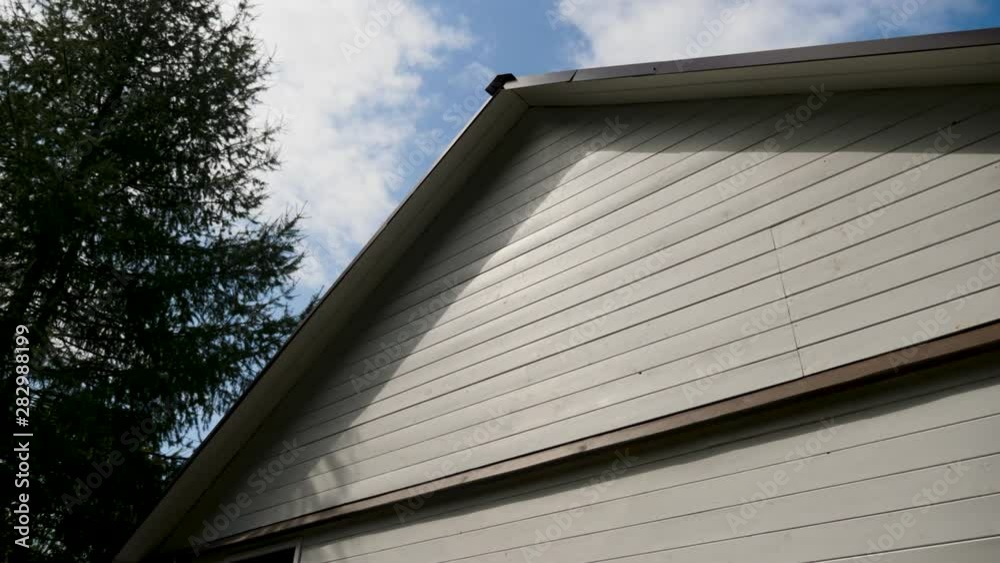 white house wooden roof with black roof with blue sky white house wooden roof with black roof with blue sky
