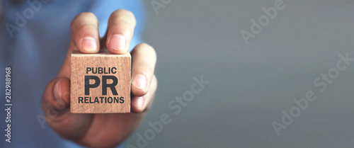 Man holding wooden cube. Pr- Public Relations photo