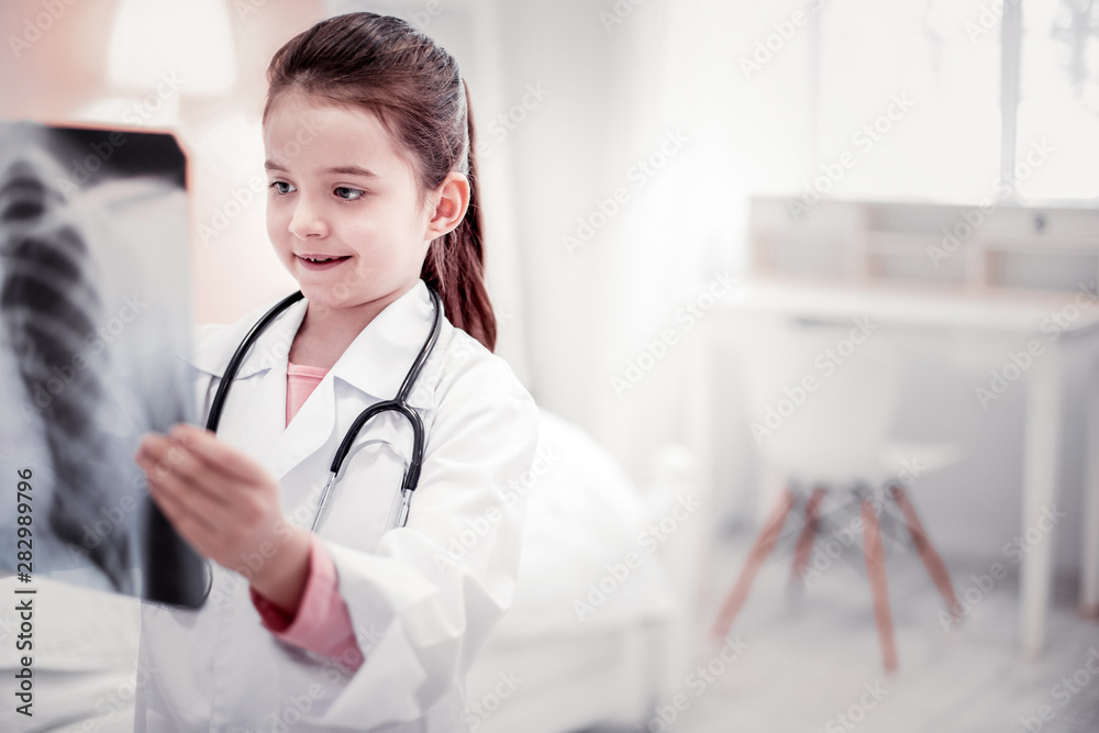 Cute cheerful girl standing with an Xray photo Cute cheerful girl standing with an Xray photo