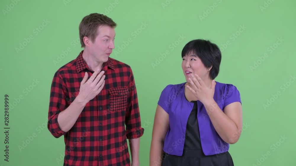 Happy young multi ethnic couple looking surprised together