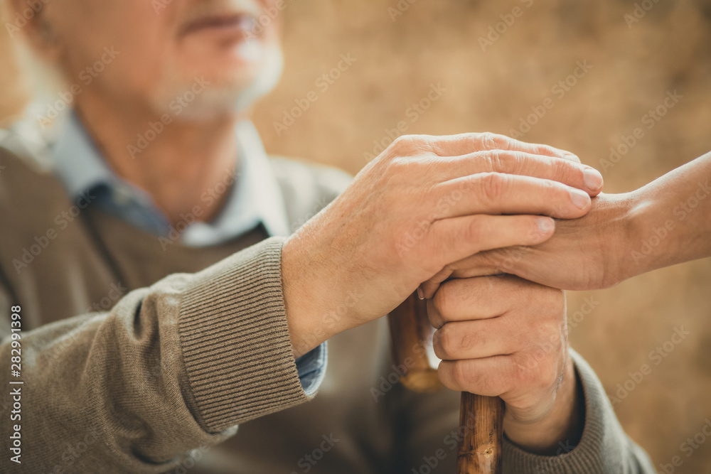 Senior patient and his doctor crossing their hands Senior patient and his doctor crossing their hands