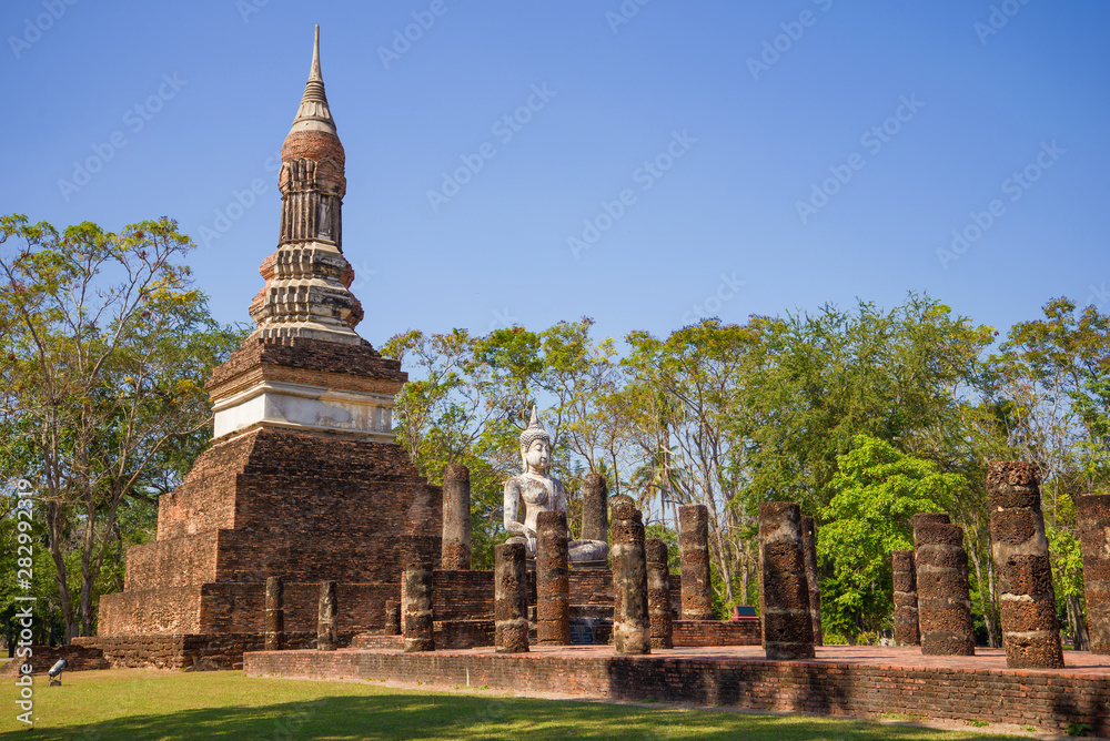 Sculpture of a sitting Buddha on the ruins of an ancient Buddhist temple, Sukhothai. Thailand