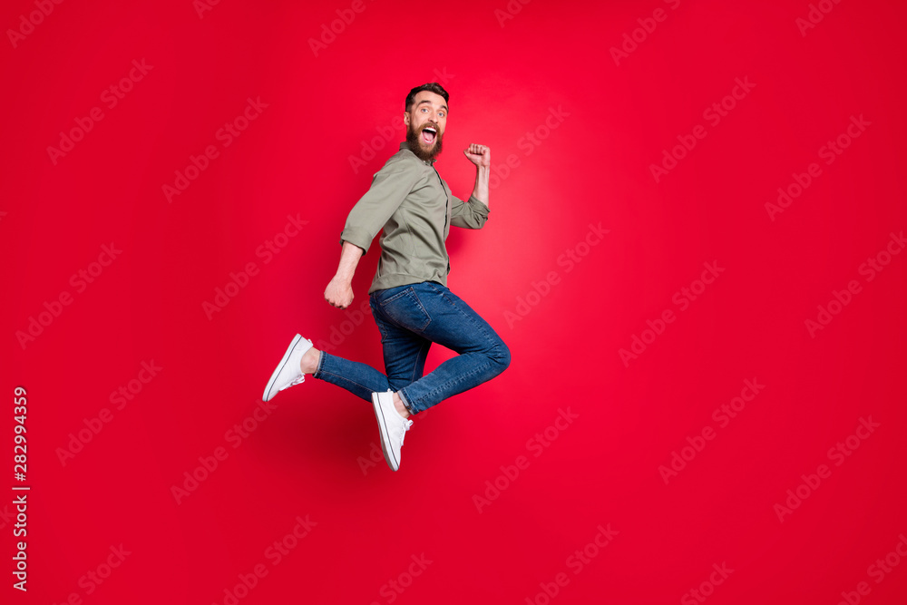 Full length body photo of man having decided to do sport and started running while isolated with red background Full length body photo of man having decided to do sport and started running while isolated with red background