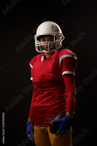 Image of rugby player woman looking into camera on empty black background