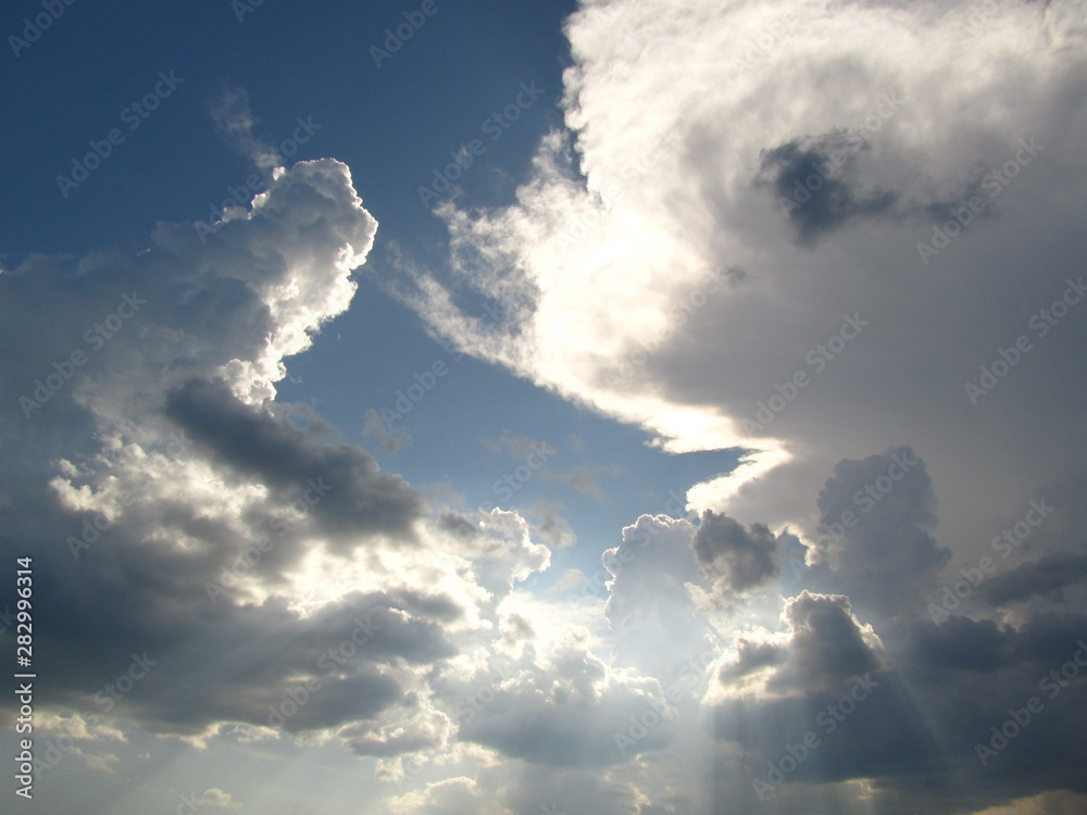 Fototapeta premium The rays of the sun shine from behind the clouds. Sky background, natural colors. Sky before a thunderstorm.