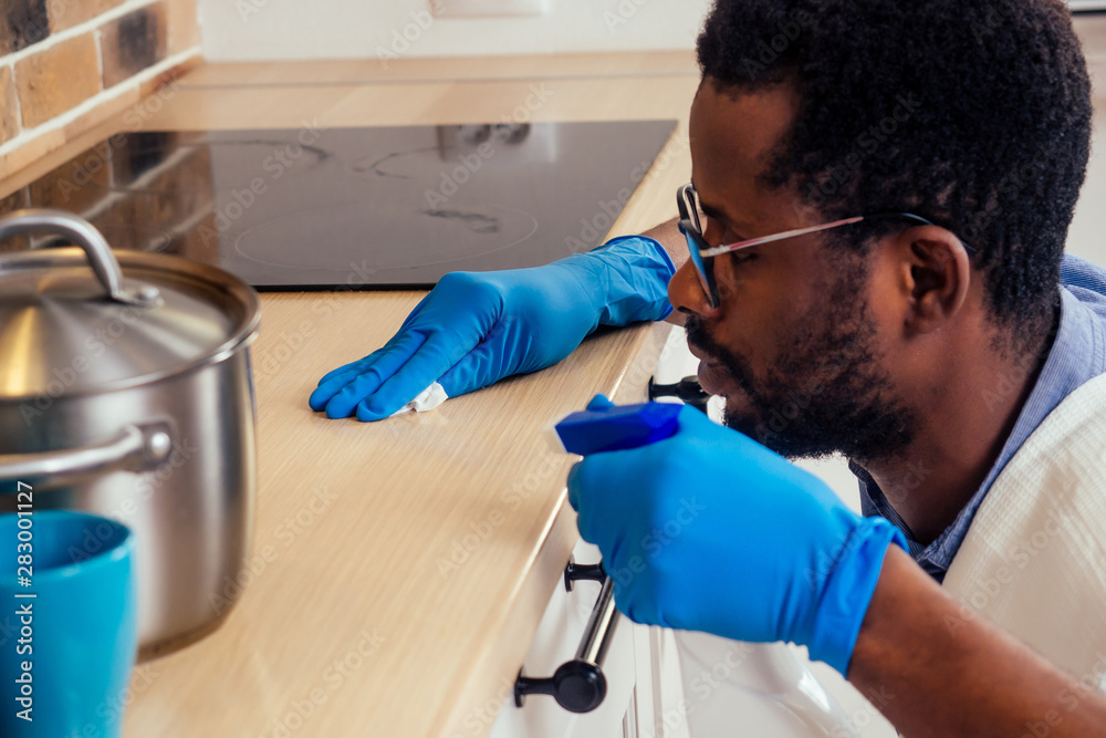 african man cleaning cooktop cooker hood at home ,Brick wall background african man cleaning cooktop cooker hood at home ,Brick wall background