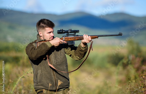 Hunter hold rifle. Focus and concentration of experienced hunter. Hunting and trapping seasons. Hunting permit. Man brutal gamekeeper nature background. Bearded hunter spend leisure hunting