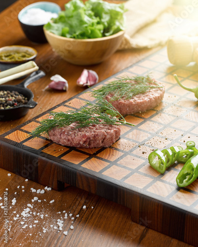 Two raw meat chops on a beautiful wooden cutting board