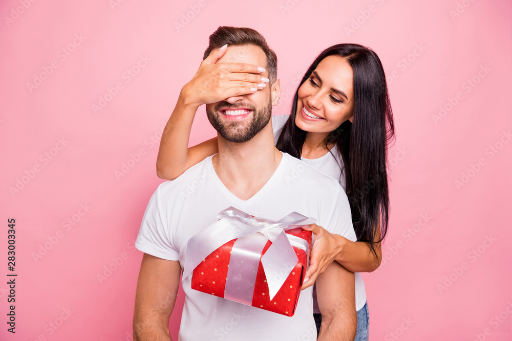 Photo of nice cute couple wearing white t-shirt of young people with girlfriend holding red package with bow congratulating his beloved one happy birthday while isolated with pink background - obrazy, fototapety, plakaty 