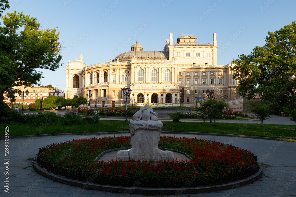 Obraz premium Ukraine, Odessa, 13th of June 2019. Side view of the national academic opera building and the park with the sculpture fountain youth during a sunny day