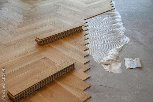 Worker laying parquet flooring. Worker installing wooden laminate flooring photo