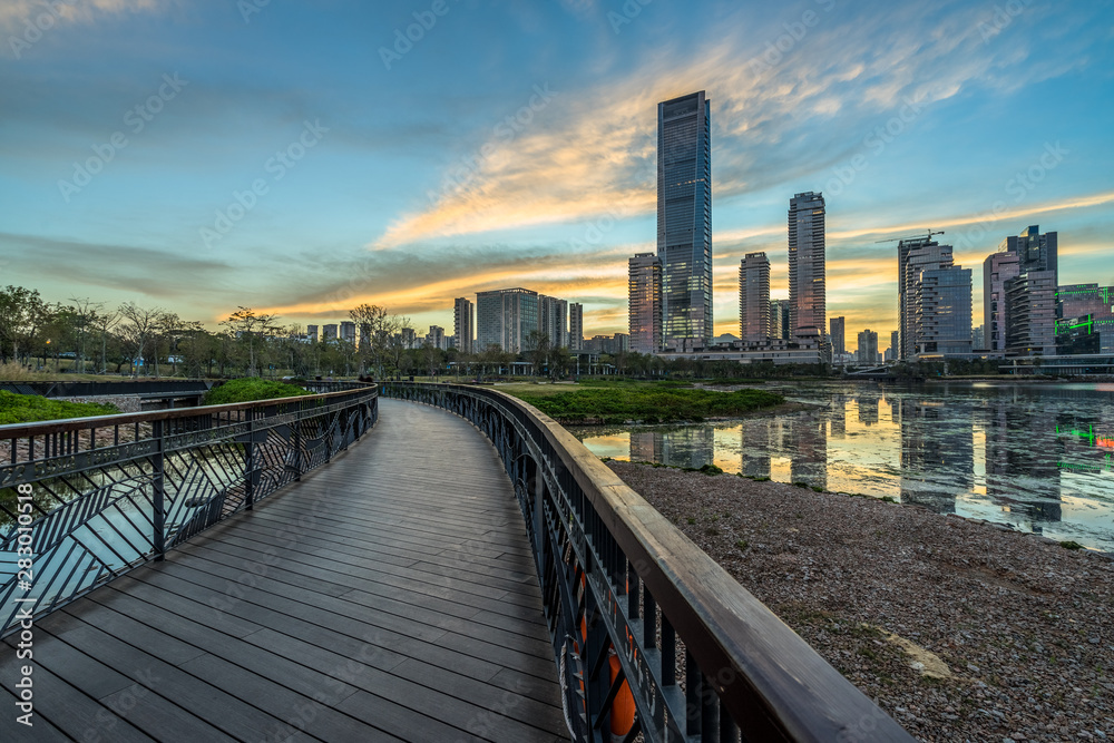 wooden pathway front of the city skyline at dusk