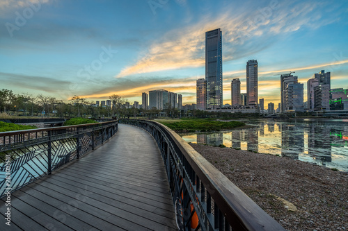 wooden pathway front of the city skyline at dusk