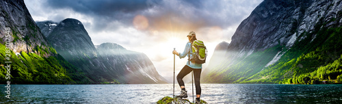 Frau mit Rucksack beim Wandern an einem Fjord in Norwegen