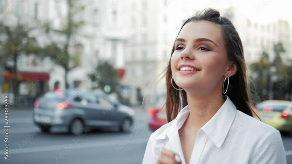 Fashion modeling. Smiling teen girl walking in city center. Fashion modeling. Smiling teen girl walking in city center.