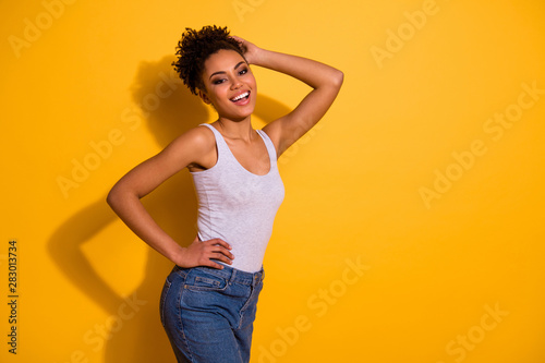 Close up side profile photo beautiful she her dark skin model lady summer vacation weekend rest relax party modern trendy look wear casual jeans denim tank-top isolated vivid yellow background