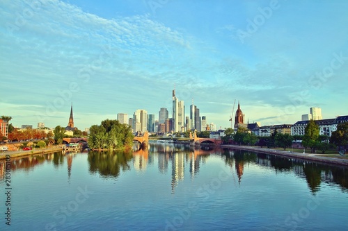 Frankfurt's Skyline reflecting in the Main River on sunrise. european city skyline and financial centre of Frankfurt. Germany Skyscraper buildings on blue sky background. Business and finance concept