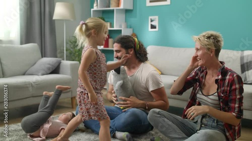 Little daughter gives high five to dad and mom during the game photo