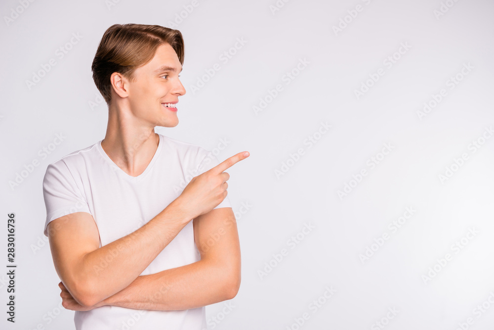 Photo of attractive guy indicating finger on banner with low prices wear casual outfit isolated white background Photo of attractive guy indicating finger on banner with low prices wear casual outfit isolated white background