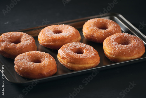 Donuts with sugar on a tray in a bar
