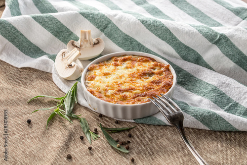Foto julienne with mushrooms and melted cheese on grey tablecloth