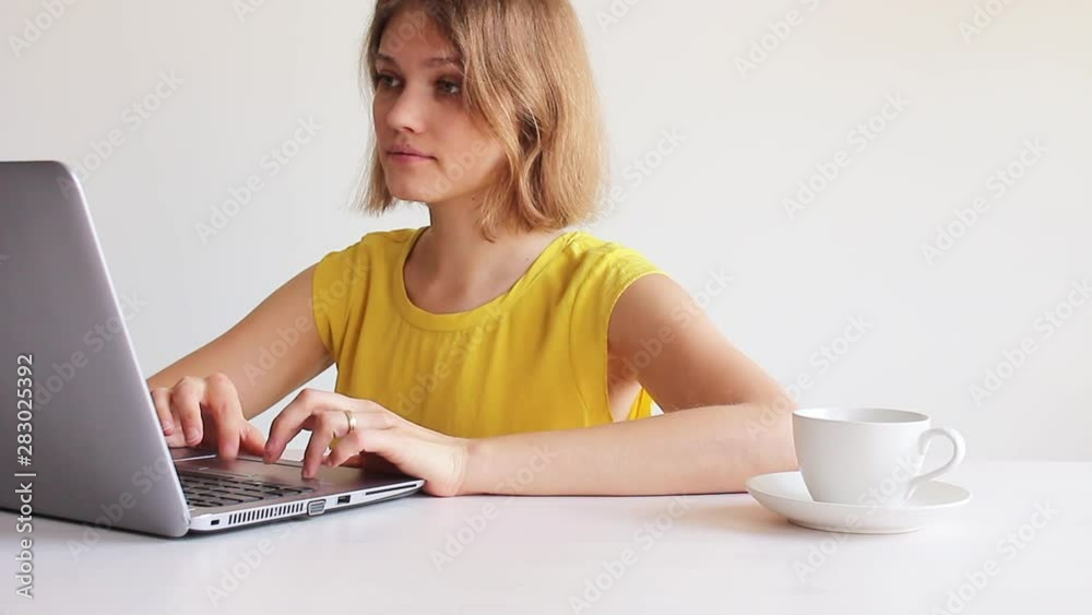 woman in yellow blouse using a comuputer on white background woman in yellow blouse using a comuputer on white background