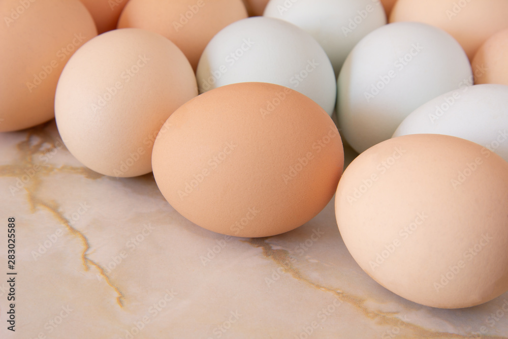 Huevos morenos y blancos encima de mármol Huevos morenos y blancos encima de mármol