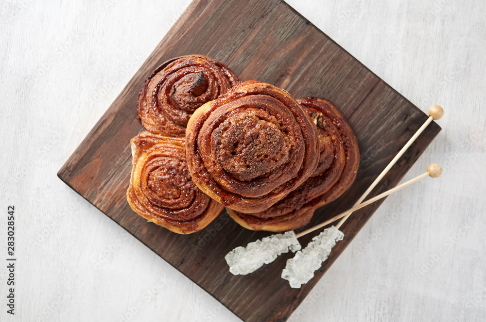 Homemade sweet cinnamon buns with sugar on wooden cut board Homemade sweet cinnamon buns with sugar on wooden cut board