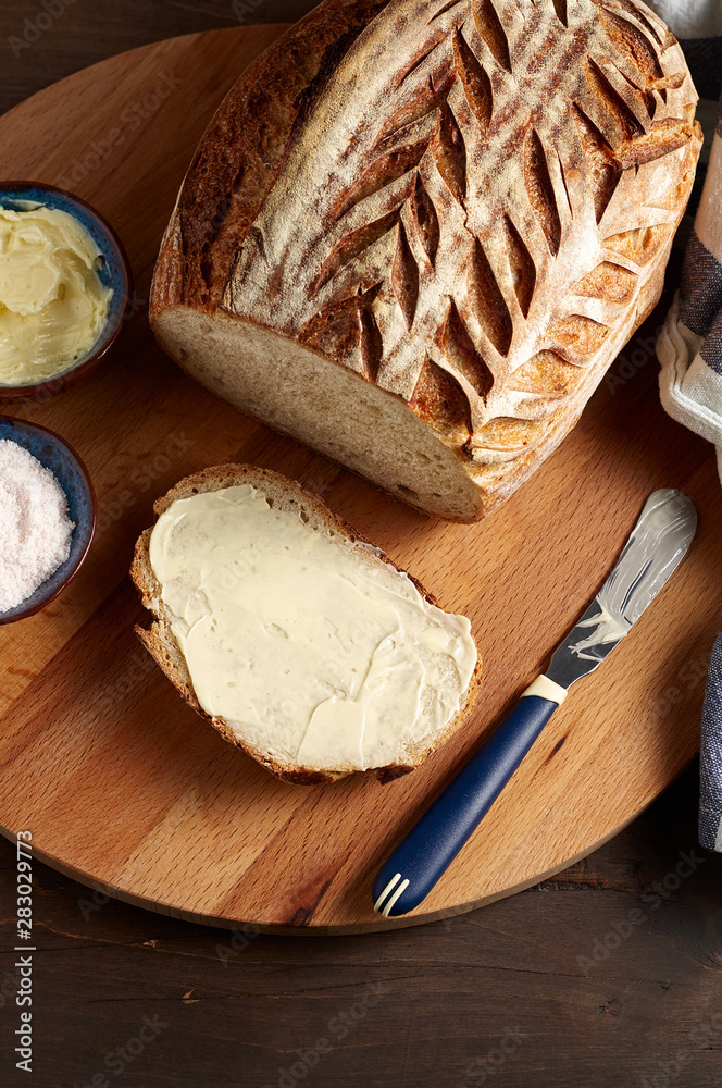 Artisan sourdough sliced toast bread with butter and pink himalayan salt on cutting board Artisan sourdough sliced toast bread with butter and pink himalayan salt on cutting board