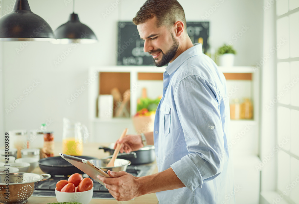 Smiling and confident chef standing in large kitchen Smiling and confident chef standing in large kitchen