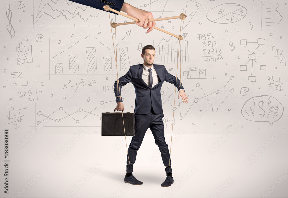 Puppet employee controlled by a big hand with documents and staffs around Puppet employee controlled by a big hand with documents and staffs around