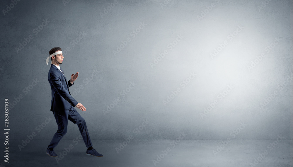 Small karate man fighting in an empty grey copy space Small karate man fighting in an empty grey copy space