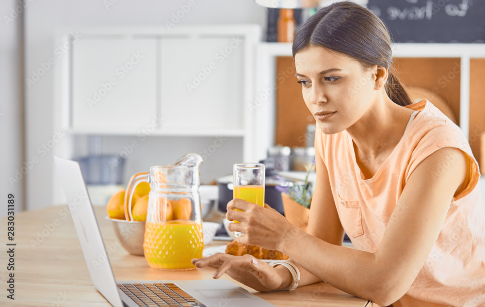 Smiling pretty woman looking at mobile phone and holding glass Smiling pretty woman looking at mobile phone and holding glass
