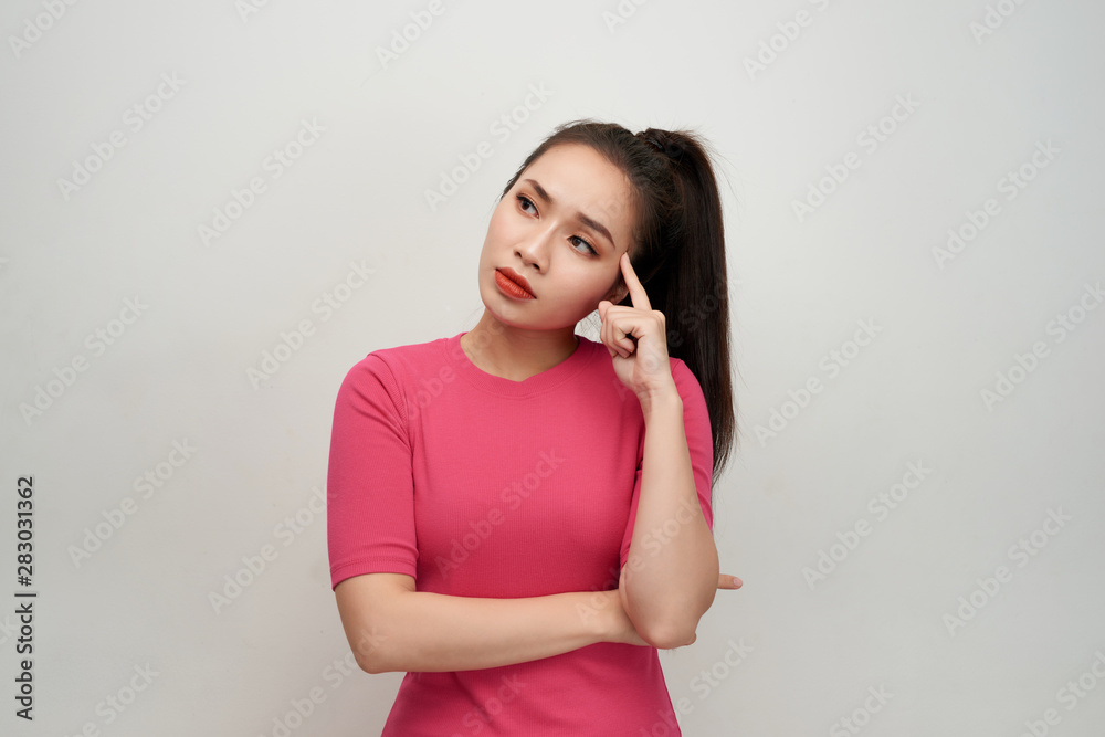 Portrait of thinking woman holding fingers on temples looking up having frustrated look trying to remember something important. Portrait of thinking woman holding fingers on temples looking up having frustrated look trying to remember something important.
