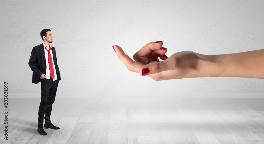 Fototapeta premium Businessman with kisses on his face in an empty space where a big hand baiting him