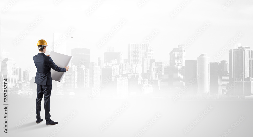 Young supervisor architect standing and looking at a big city panorama Young supervisor architect standing and looking at a big city panorama
