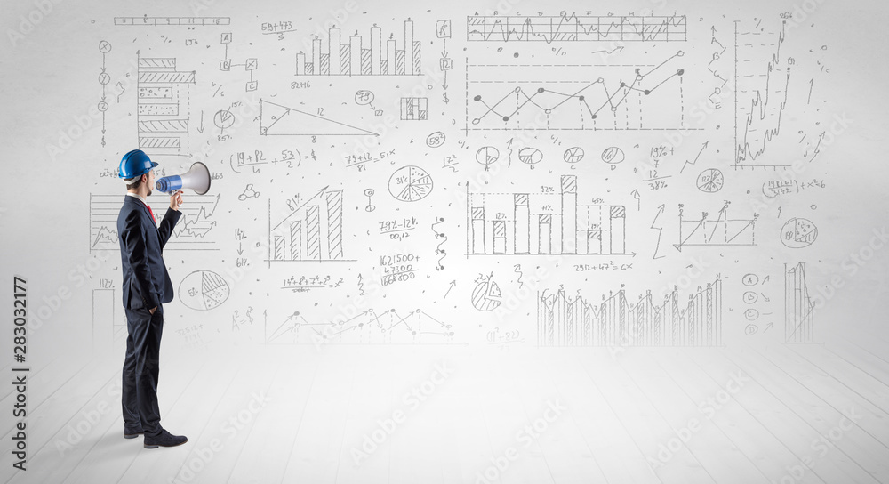 Engineer with construction helmet holding a plan and standing with graphs, charts and reports on the background Engineer with construction helmet holding a plan and standing with graphs, charts and reports on the background