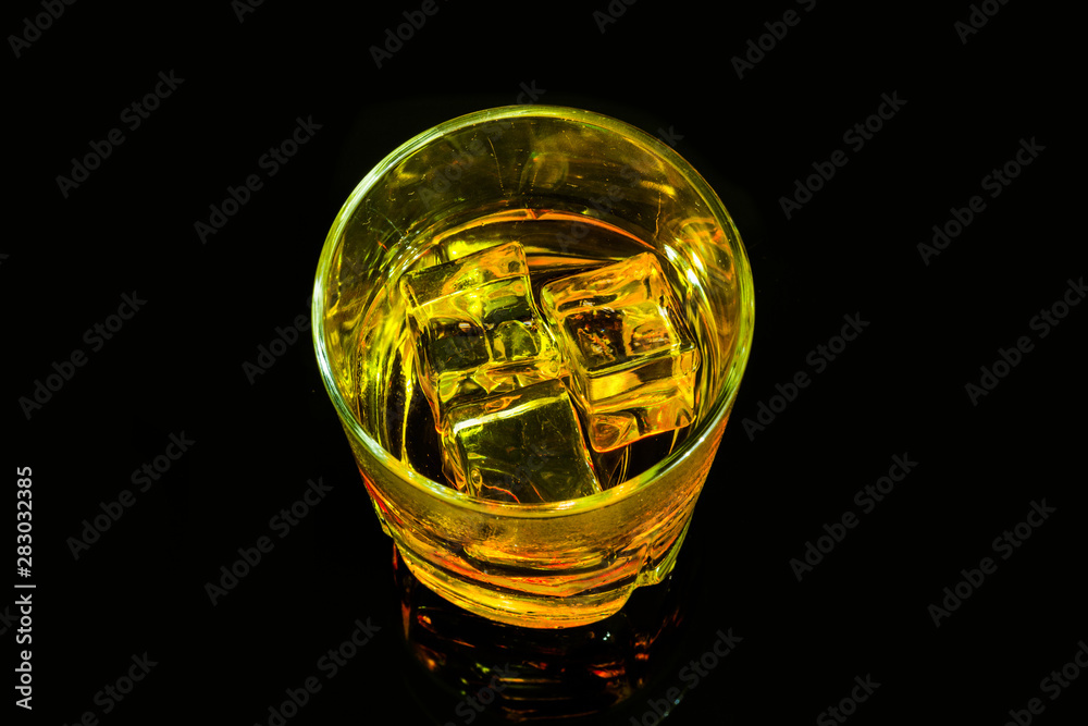 Glass of scotch whiskey and ice on a black background Glass of scotch whiskey and ice on a black background