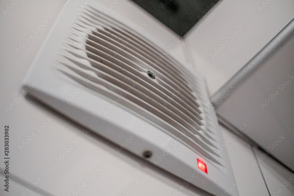 Close-up of a white range hood with an indicator on the wall in the bathroom Close-up of a white range hood with an indicator on the wall in the bathroom