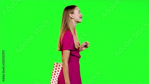 Stylish happy woman walks, smiles and waves 