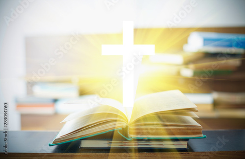 Christian cross in open books © arybickii