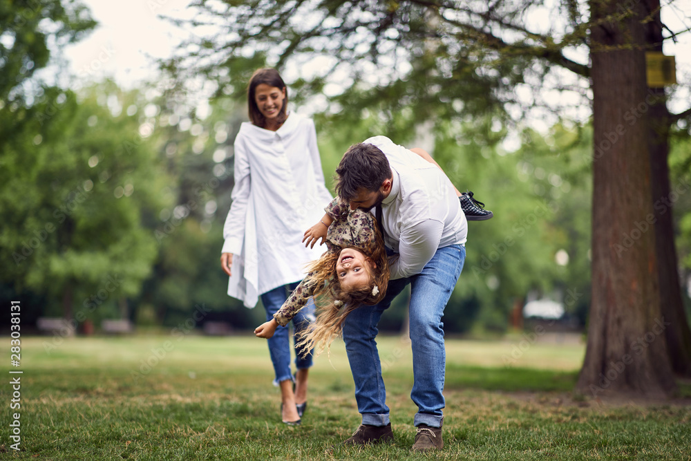 smiling family playing and spinning in park