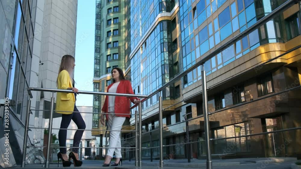custom made wallpaper toronto digitalWide angle two business women at break, talking on the street. Background modern skyscrapers and business center